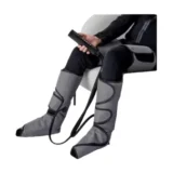 Bottes de compression réglables Decathlon portées avec leur télécommande, sur fond blanc